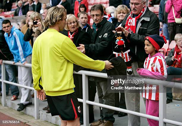 Bolo Zenden of Sunderland offers his training top to a young girl in the crowd