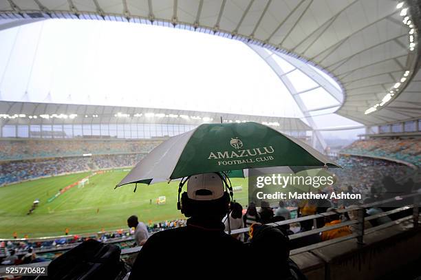 Radio Commentator holds up an Amazulu FC umbrella in the stands during the first ever football match in the Moses Mabhida Stadium in Durban, South...