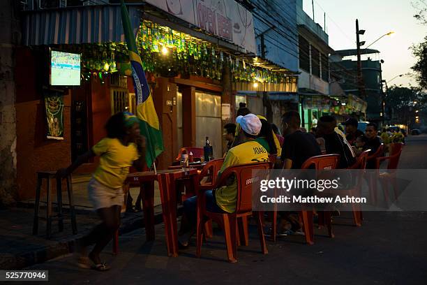 Fans gather around a television outside a bar in Gardenia Azul, Barra de Tijuca, Rio de Janeiro, Brazil for the FIFA World Cup 2014 to watch the...