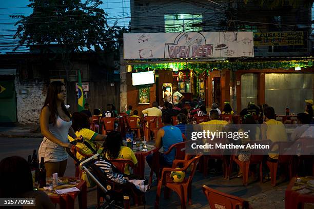 Fans gather around a television outside a bar in Gardenia Azul, Barra de Tijuca, Rio de Janeiro, Brazil for the FIFA World Cup 2014 to watch the...