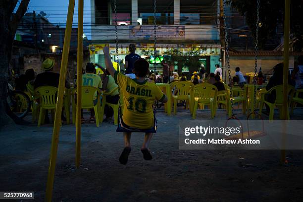 Fans gather around a television outside a bar in Gardenia Azul, Barra de Tijuca, Rio de Janeiro, Brazil for the FIFA World Cup 2014 to watch the...