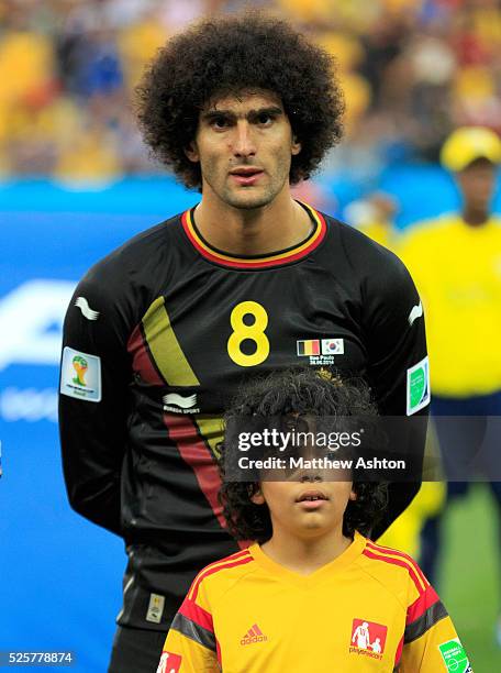 Marouane Fellaini of Belgium with a mascot with similar large hair