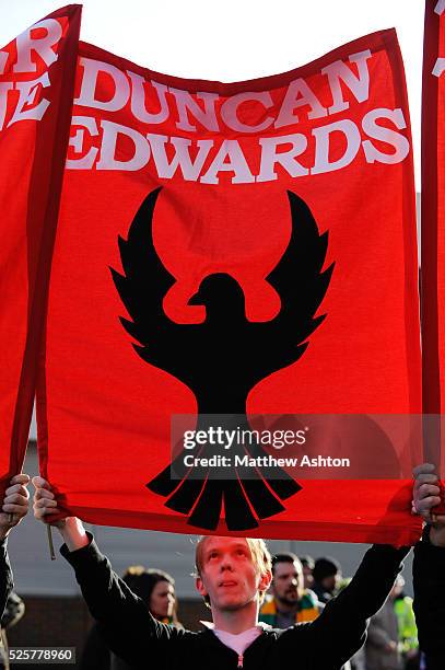 Fan of Manchester United remembering those who died in the Munich Air Disaster on 6th February 1958 by holding up banner of Duncan Edwards at Old...