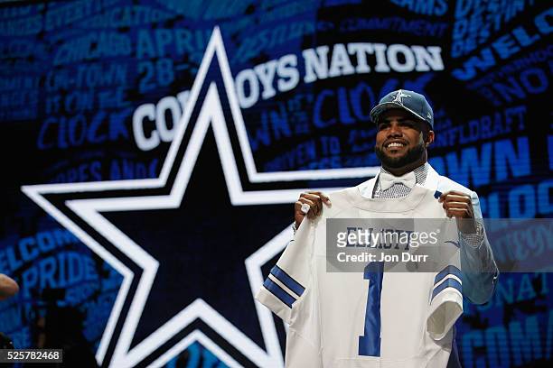 Ezekiel Elliott of Ohio State holds up a jersey after being picked overall by the Dallas Cowboys during the first round of the 2016 NFL Draft at the...