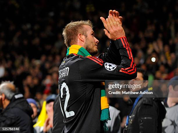 David Beckham of AC Milan puts a Love United Hate Glazer green and yellow scarf around his neck as he leaves the field in protest of the American...