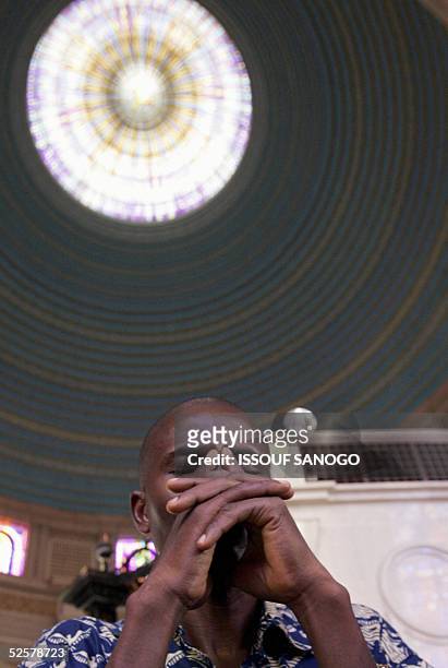 Man prays for Pope John Paul II at Notre Dame de la Paix basilica in Yamoussoukro, 02 Avril 2005. Pope John Paul II is drifting in and out of...