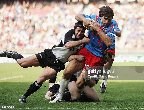 Olivier Sarramea, the Stade Francais fullback scores his second try despite being tackled by Mark Mayerhofler during the Heineken Cup Quarter Final...