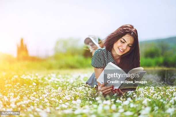 hermosa chica leyendo un libro - mujer leyendo libro en el parque fotografías e imágenes de stock