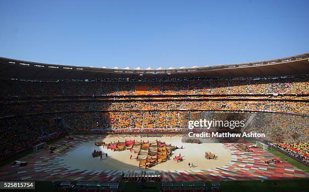 Dancers hold up flags which make up the shape of South Africa at Soccer City stadium during the opening ceremony of the 2010 FIFA World Cup