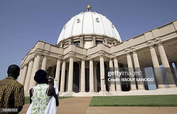 An Ivorian couple and their baby arrive, 03 April 2005 for a mass in Yamoussoukro's "Notre Dame de la paix" basilic, a day after the pontiff's death....