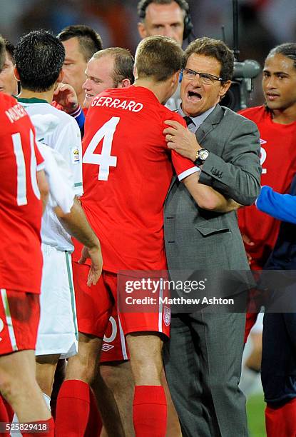 Fabio Capello manager / head coach of England celebrates the 0-1 victory over Slovenia with Steven Gerrard