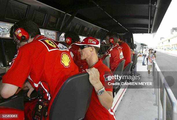 German Ferrari driver Michael Schumacher watches a control screen on the pit wall of the Sakhir racetrack after he retired of the Bahrain Grand Prix...