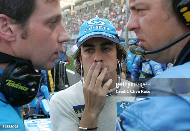 Fernando Alonso of Spain and Renault ponders his race tactics on the grid prior to the Bahrain F1 Grand Prix at the Bahrain International Circuit on...