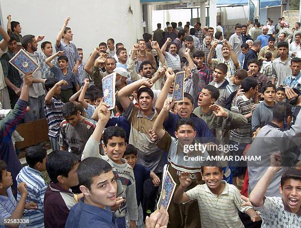 Holding up books with Islamic covers, people protest outside the Aziz al-Hakim mosque in the city of Ramadi, 100 kms west of Baghdad 03 April 2005....