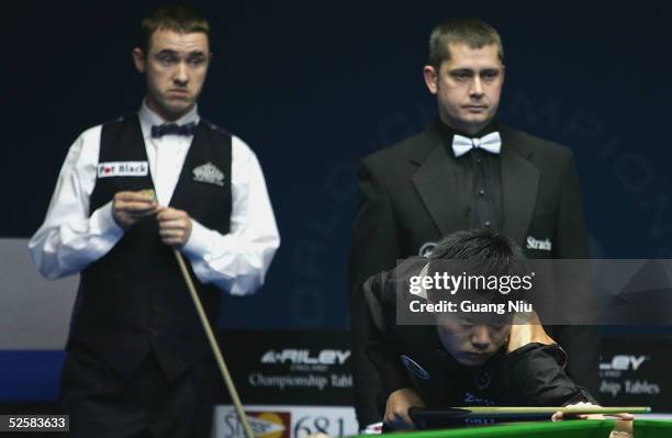 Stephen Hendry of Scotland looks at Ding Junhui of China playing a ball during the final match of China Snooker Open on April 3, 2005 in Beijing,...