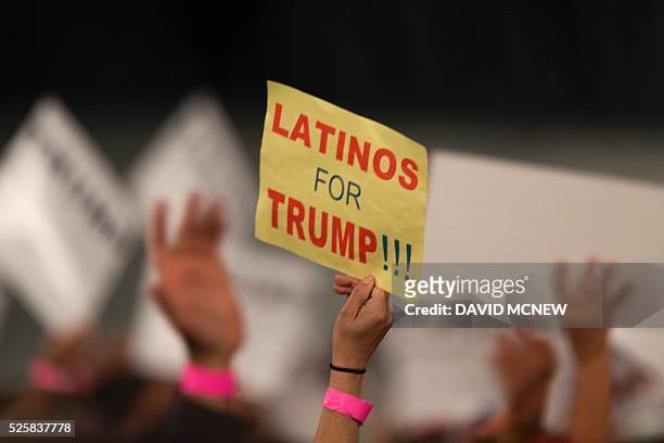Woman hoods a sign expressing Latino support for Republican presidential candidate Donald Trump at his campaign rally at the Orange County Fair and...