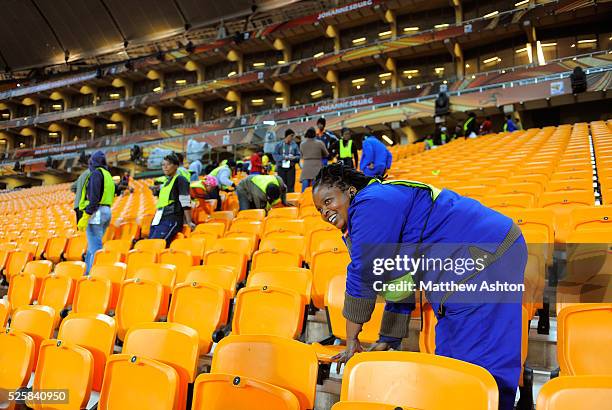 Cleaners polish the seats in Soccer City Stadium, Johannesburg ahead of the final of the 2010 FIFA World Cup South Africa