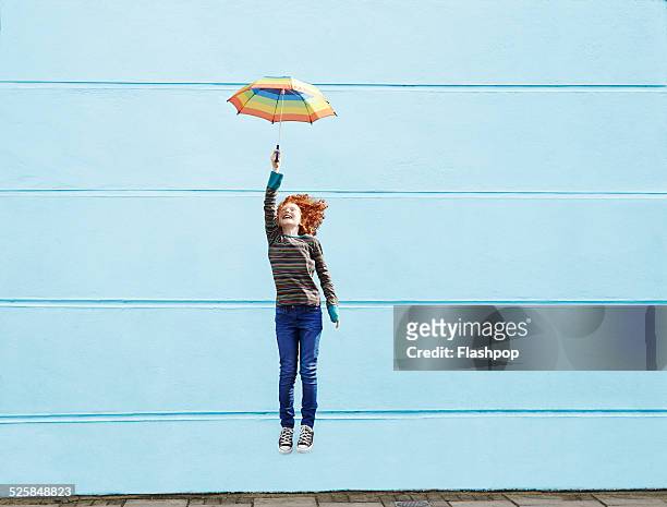 girl jumping with umbrella - motivation stock-fotos und bilder