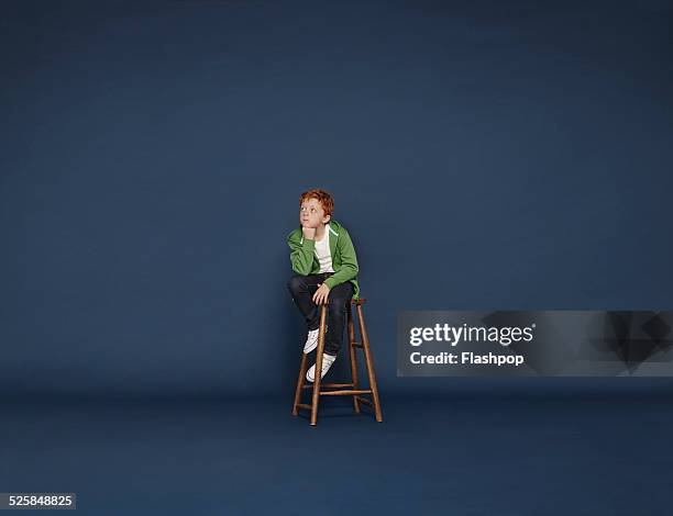 boy thinking - chairs in studio stockfoto's en -beelden