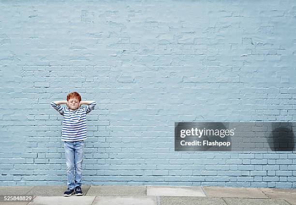 boy with hands covering his ears - vestido a rayas fotografías e imágenes de stock