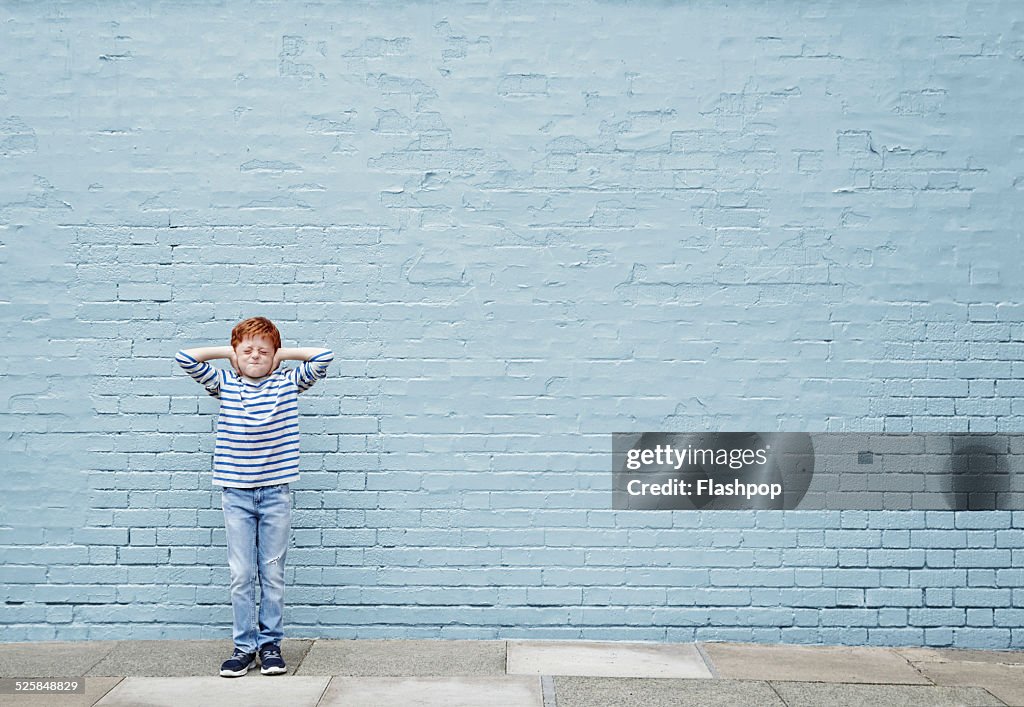 Boy with hands covering his ears