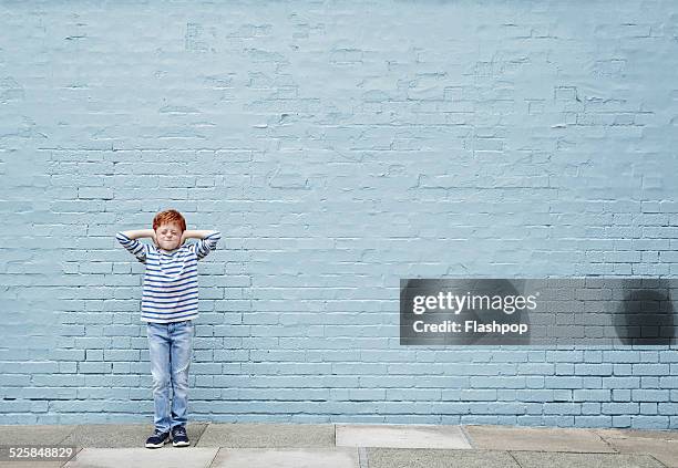 boy with hands covering his ears - hands covering ears stock pictures, royalty-free photos & images
