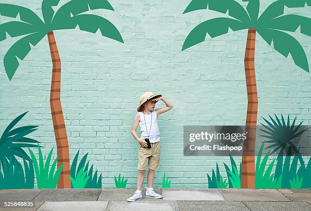 boy dressed as an adventurer with jungle scene - entdeckung stock-fotos und bilder