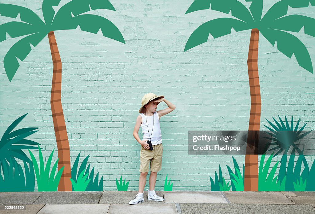 Boy dressed as an adventurer with jungle scene