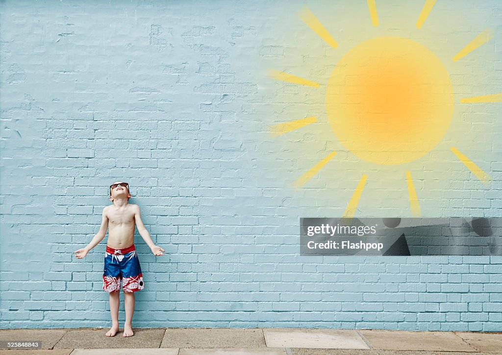 Boy wearing swimming shorts. Cartoon of sun