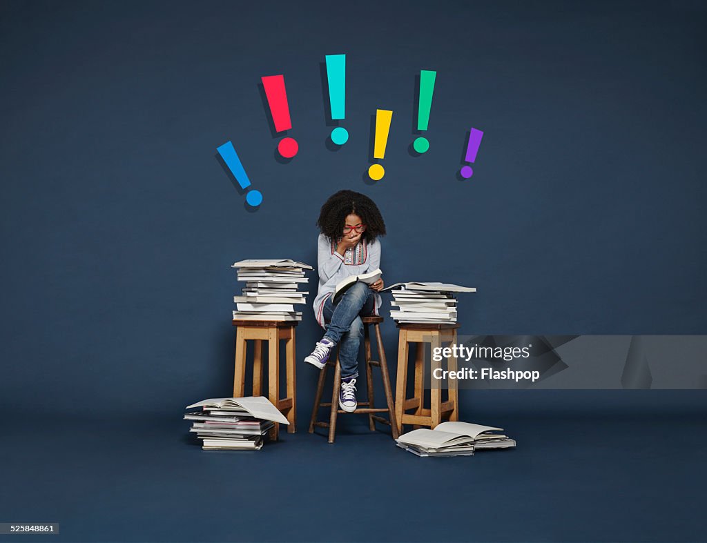 Girl reading book and looking surprised