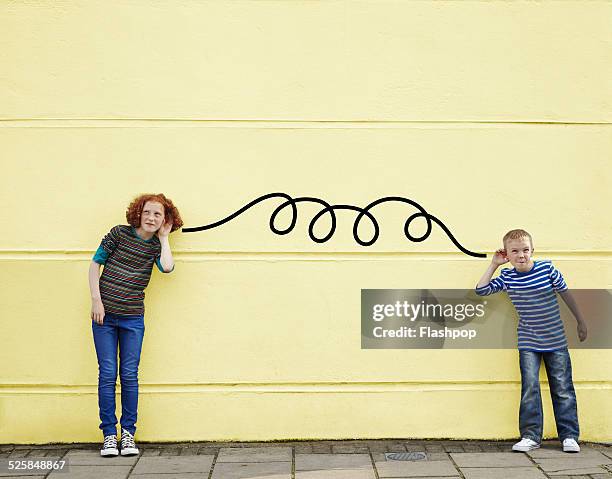 boy and girl listening via cartoon wire - escutando - fotografias e filmes do acervo