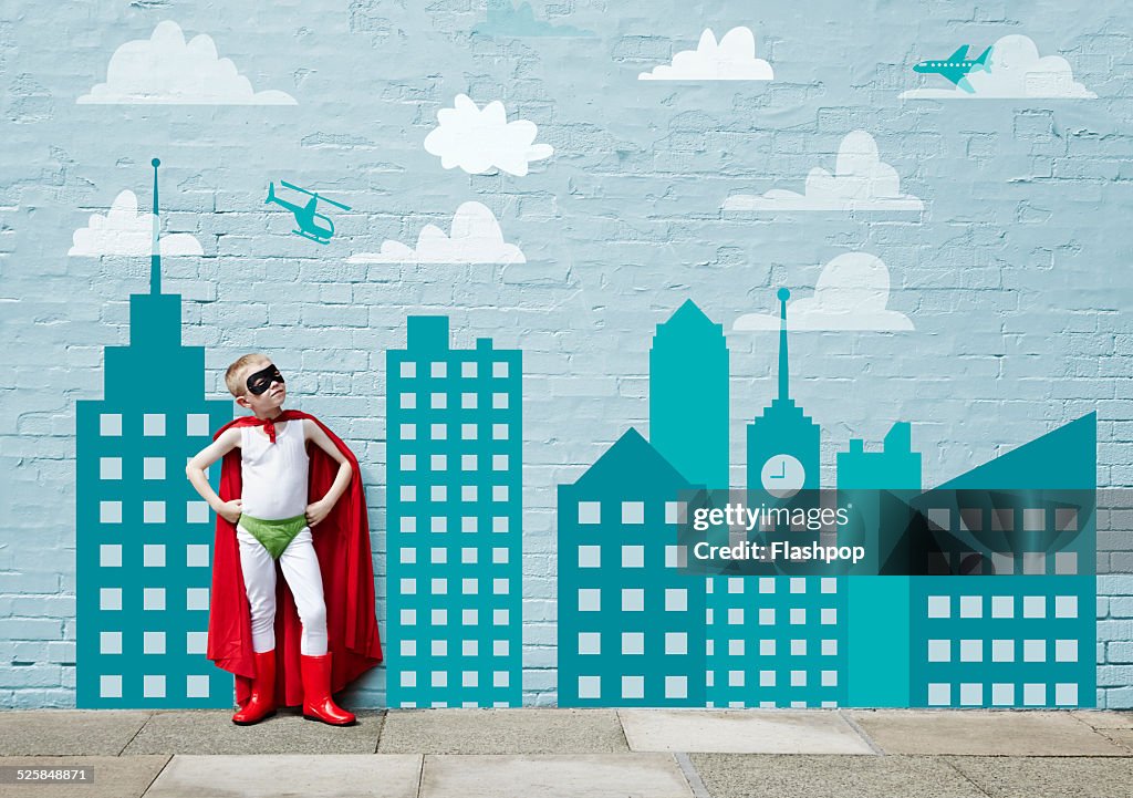 Boy dressed as a superhero. Cartoon city skyline