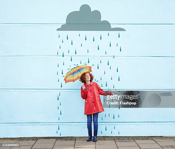 girl holding umbrella with cartoon rain cloud - tempo atmosferico foto e immagini stock