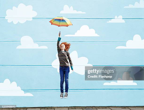 girl jumping with umbrella - kids imagination stock-fotos und bilder