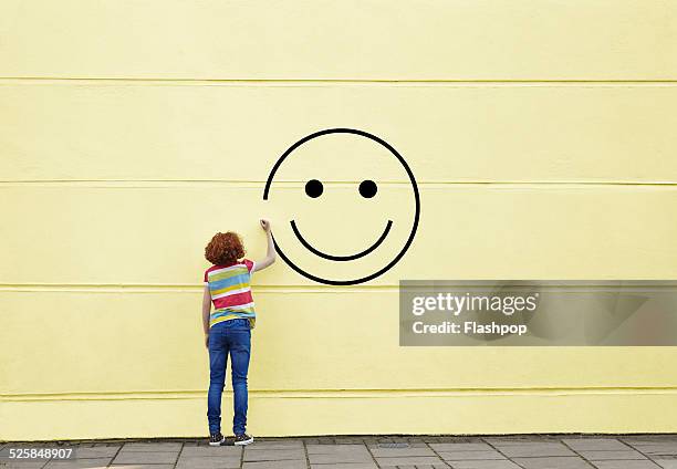 girl drawing smiley face on to a wall - uttryck och känslor bildbanksfoton och bilder