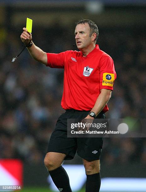 Referee Jon Moss shows a yellow card