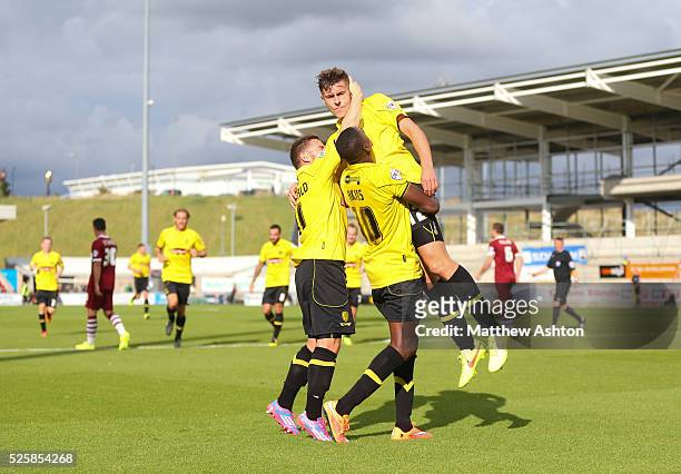 Jacob Blyth of Burton Albion is lifted aloft by his team mates as he plays down his celebration after scoring to make it 0-1, having previously...