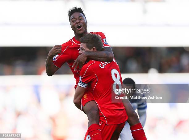 Raheem Sterling of Liverpool jumps on Steven Gerrard of Liverpool as he celebrates scoring the winning goal to make it 2-3