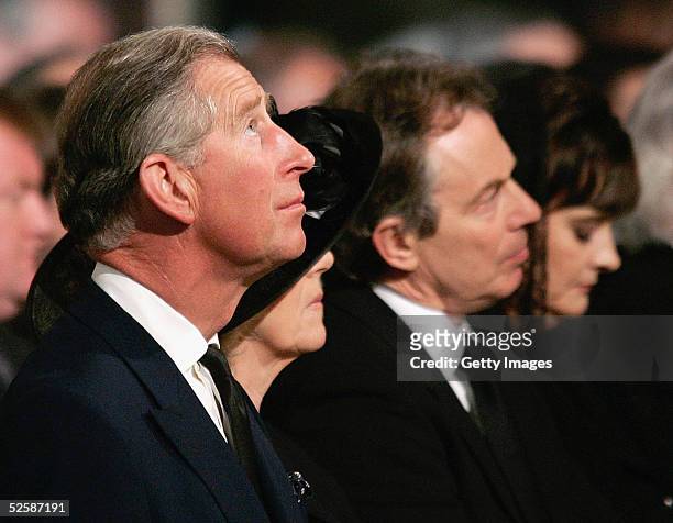 Britain's Prince Charles looks up as he sits with Camilla Parker-Bowles , Britain's Prime Minister Tony Blair and his wife Cherie attend a service in...