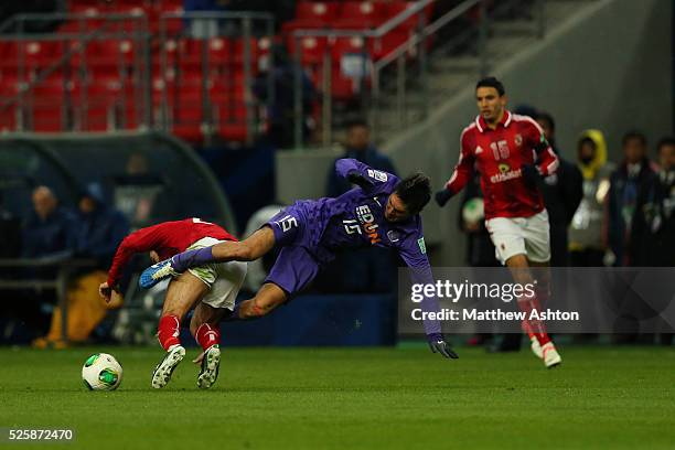 Yojiro Takahagi of Sanfrecce Hiroshima takes a tumble over Ahmed Fathi of Al-Ahly SC