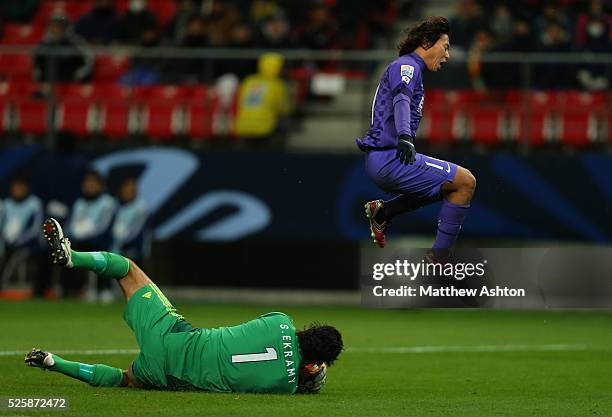 Hisato Sato of Sanfrecce Hiroshima jumps over Sherif Ekramy of Al-Ahly SC