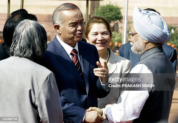 President of the Republic of Uzbekistan Islam A. Karimov gestures while shaking hands with Indian Prime Minister Manmohan Singh as Indian President...