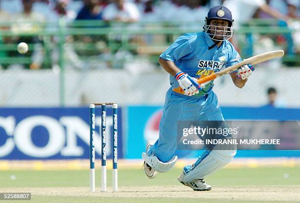 Indian cricketer Mahender Dhoni watches a ball to the boundary during the second one day international match between India and Pakistan in...