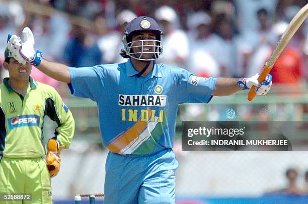 Indian cricketer Mahender Dhoni celebrates after scoring a century during the second one day international match between India and Pakistan in...