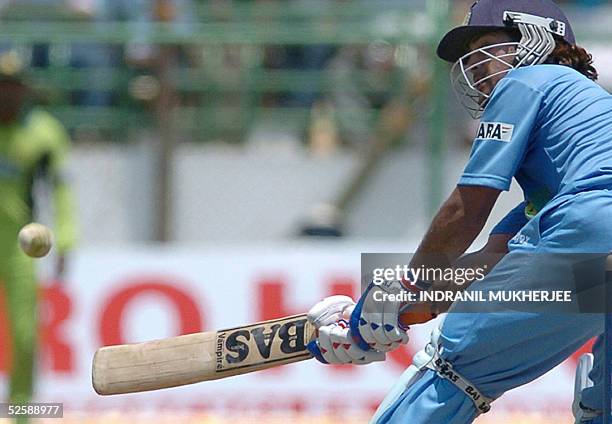 Indian cricketer Mahender Dhoni hits a boundary on his way to a century during the second one day international match between India and Pakistan in...