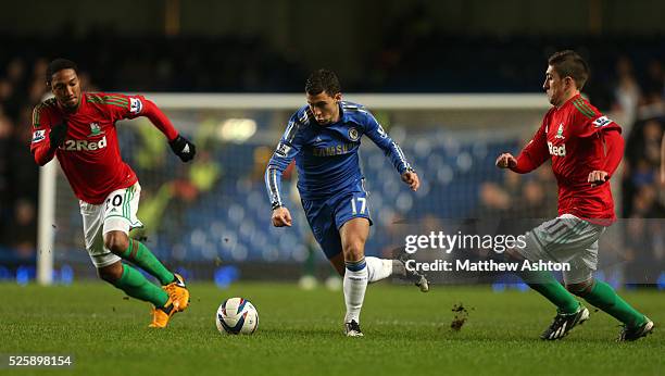 Eden Hazard of Chelsea gets away from Pablo Hernandez and Jonathan de Guzman of Swansea City