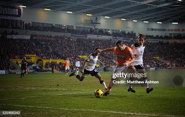Charlie Adam of Blackpool tackles Luka Modric of Tottenham Hotspur at Bloomfield Road the home stadium of Blackpool