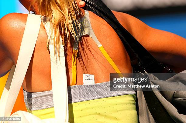 Maria Sharapova of Russia walks off court with a label showing from her dress at the Australian Open, 2013