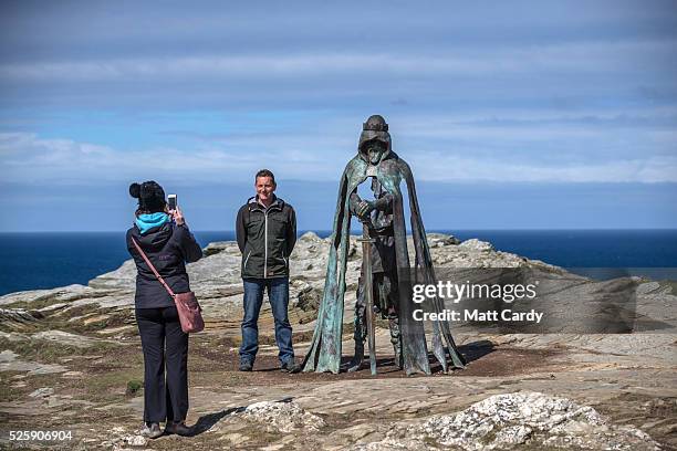 People take photographs of the new 'Gallos' sculpture that has been erected at Tintagel Castle in Tintagel on April 28, 2016 in Cornwall, England....