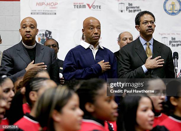 Reverend Run, his brother hip hop entrepreneur Russell Simmons and New Jersey Attorney General Peter C. Harvey stand during the playing of the...